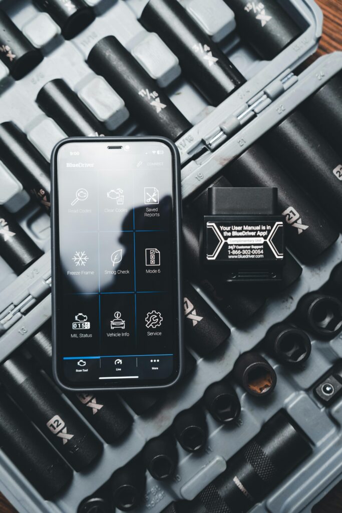 Close-up of a smartphone displaying a diagnostic app with a vehicle diagnostic tool and socket set.
